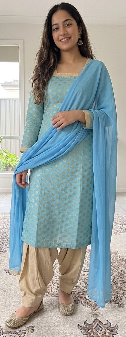 Woman wearing a light blue silk salwar kameez with long sleeves, neutral pants, and matching blue dupatta